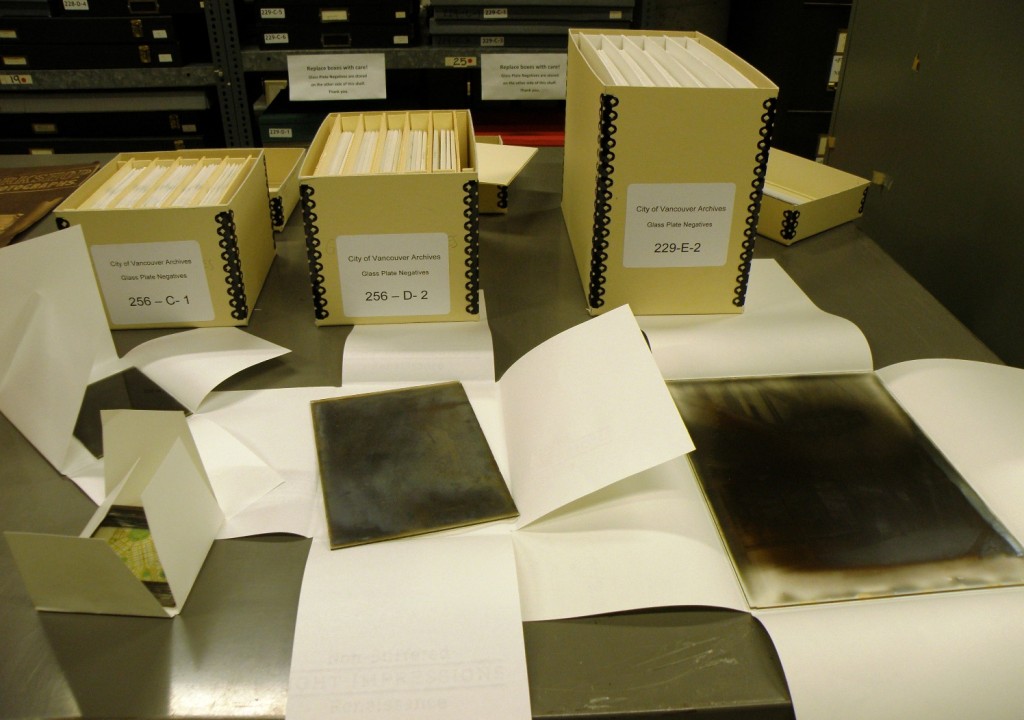Three standard box sizes and some examples of glass negatives with their four-flap enclosures open.
