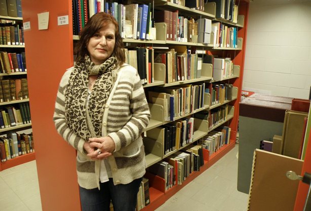 Doris beside our reference library collection