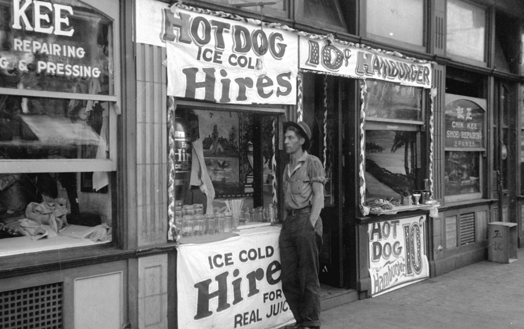 Man standing outside shallow building at Pender and Carrall Streets, 1936. Reference code: AM54-S4-: Bu N158.3 