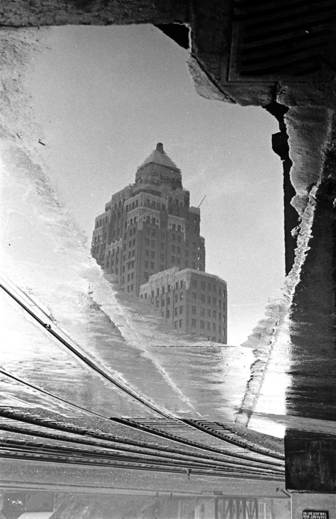 Train tracks and a reflection of the Marine Building in the water (c. 1939). Reference code: AM640-S1-: CVA 260-999.