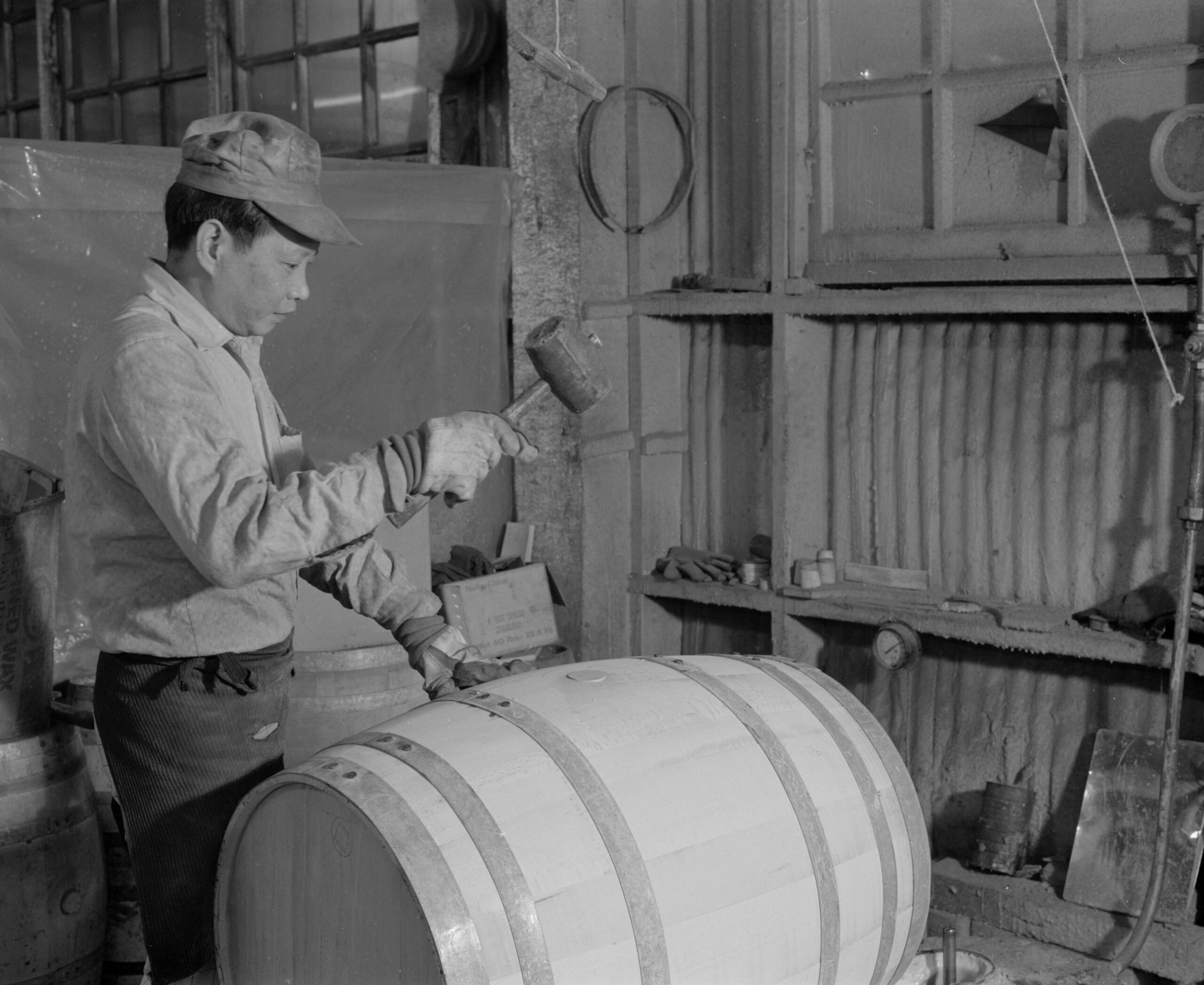 Worker at Sweeney Cooperage using a mallet to plug a barrel, 1978. Reference code: AM1376-F19-: 2018.003.09