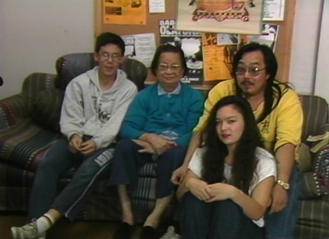 Still of Sid Chow Tan, his grandmother, and children (ca. 1990). L-R: Jordan Tan, Wong Nooy Chow, Sid Chow Tan, Kalee Tan. Reference code: AM1698-S6-: 2023-092.0001