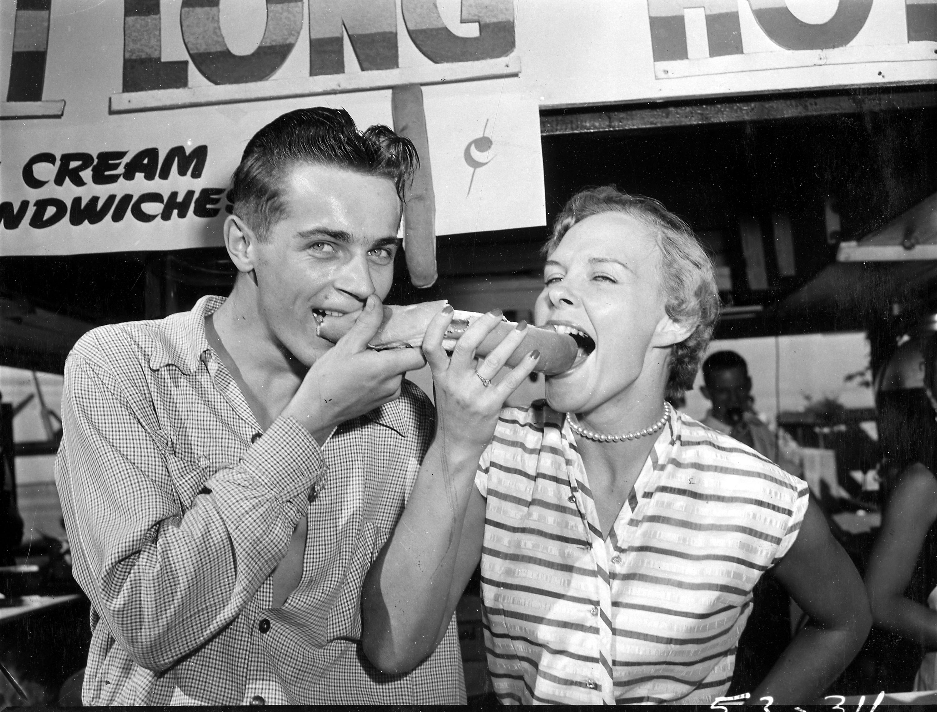 2 people sharing a hot dog