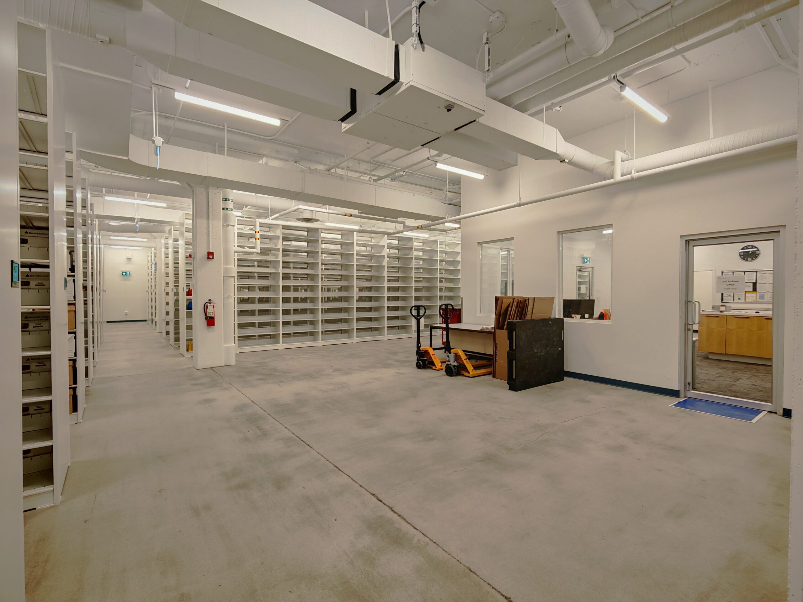 Standard-depth static shelving surrounding staging area for incoming records transfers