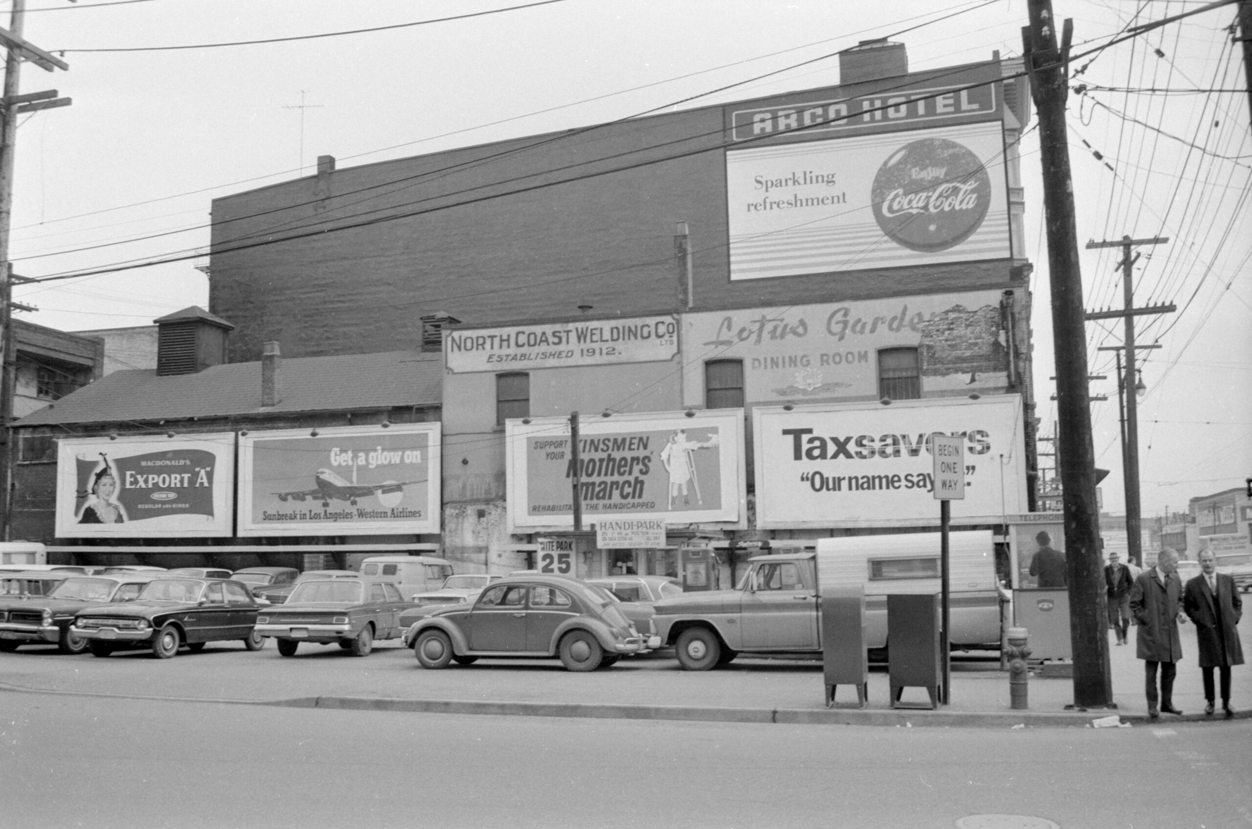 West Pender Street parking lot with billboards and a Volkswagen beetle, probably 1968. Reference code: COV-S644-: CVA 1095-14240